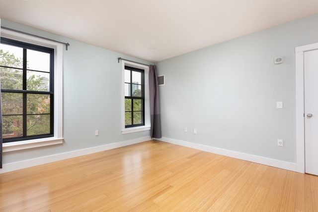 an empty room with windows and closet