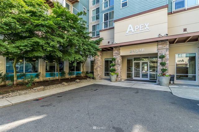 a view of a brick building with a large window and a large tree
