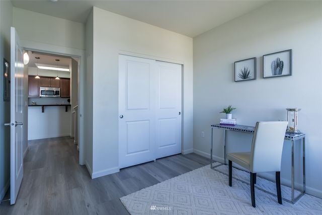a view of a workspace room with wooden floor table and chair