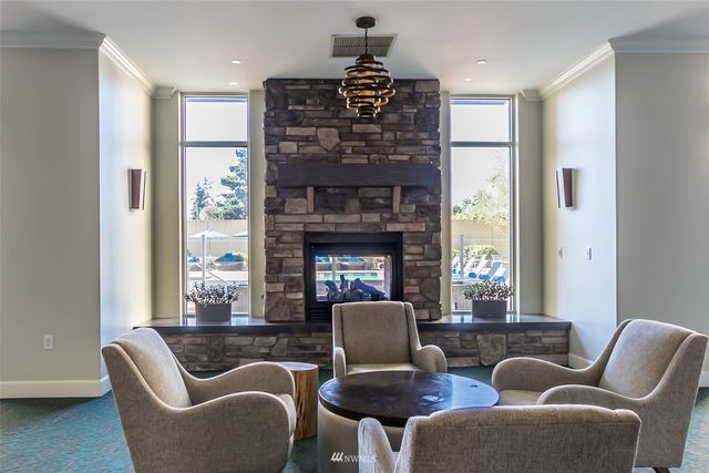 a living room with furniture a fireplace and a large window