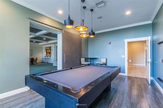 a room with pool table and wooden floor