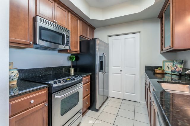 a kitchen with stainless steel appliances granite countertop a stove microwave and refrigerator