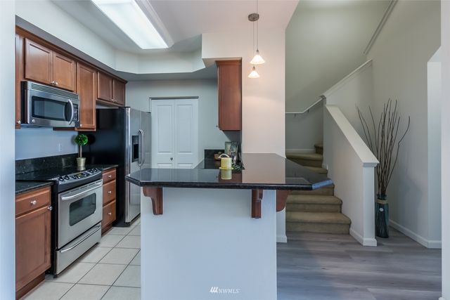 a kitchen with stainless steel appliances kitchen island a stove top oven a sink and a refrigerator