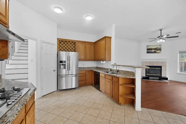 a kitchen with stainless steel appliances granite countertop a refrigerator and a stove top oven