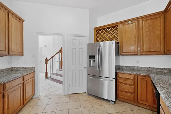 a kitchen with granite countertop a refrigerator and a sink