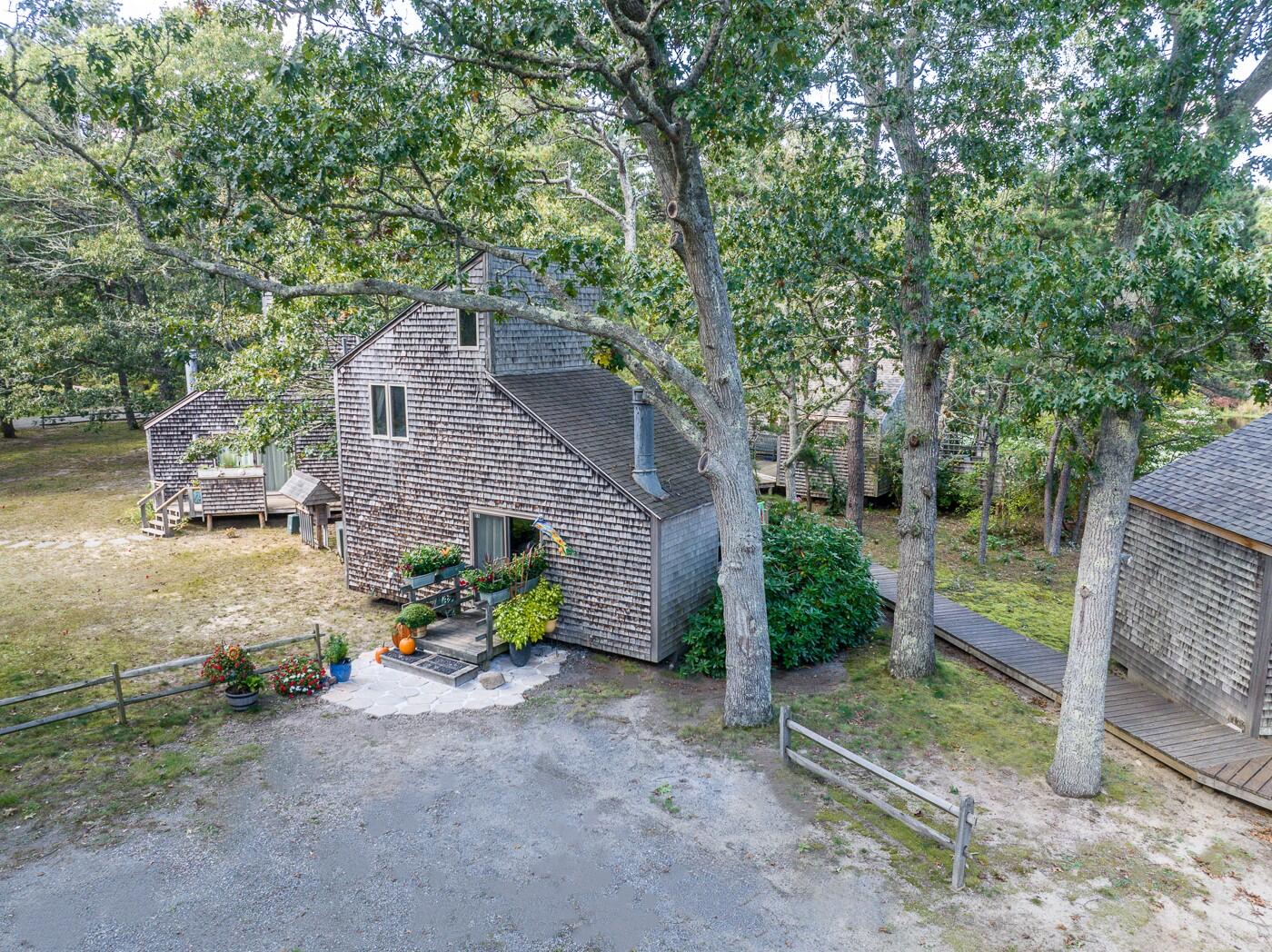 1780 Route 6, Unit D3 Wellfleet, MA 02667 - Photo 22 of 25 a view of a house with a yard and a large tree
