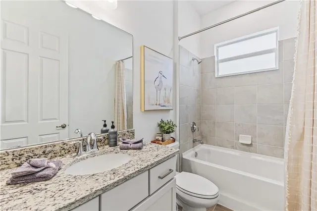 a bathroom with a granite countertop sink a toilet and a bathtub