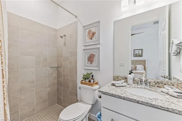 a bathroom with a granite countertop sink mirror vanity and toilet