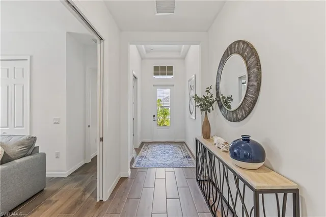 a view of a hallway with wooden floor and a mirror