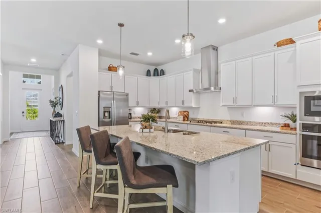 a kitchen with a white cabinets and chairs