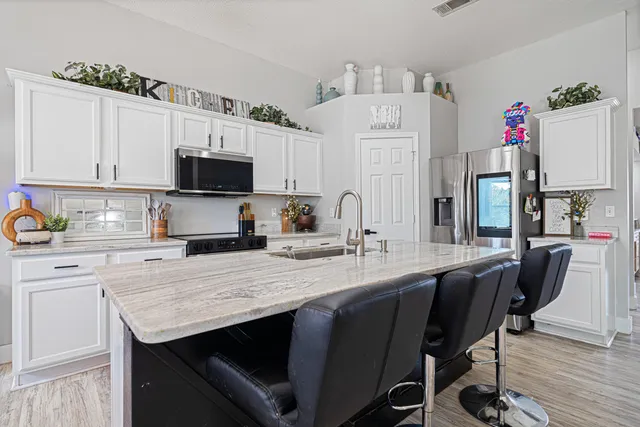 a kitchen with granite countertop a sink appliances and cabinets