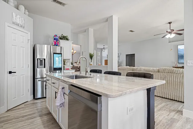 a view of kitchen island a sink and wooden floor