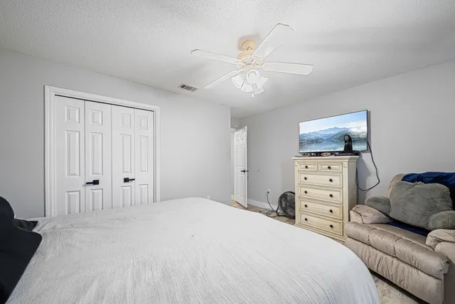 a bedroom with a bed and ceiling fan