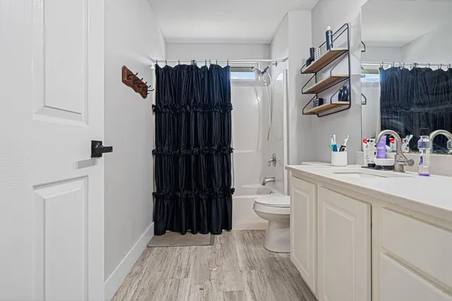 a bathroom with a sink a toilet and shower