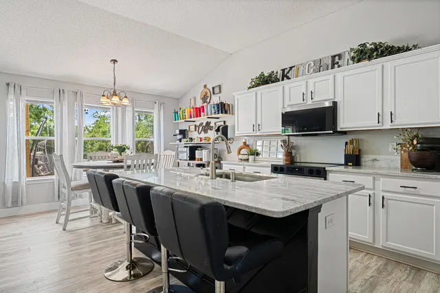 a kitchen with a stove a sink a dining table and chairs