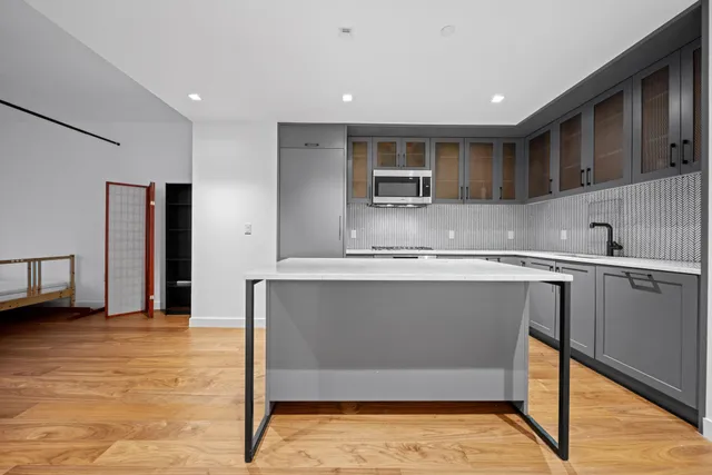 a kitchen with kitchen island a counter top space cabinets and stainless steel appliances