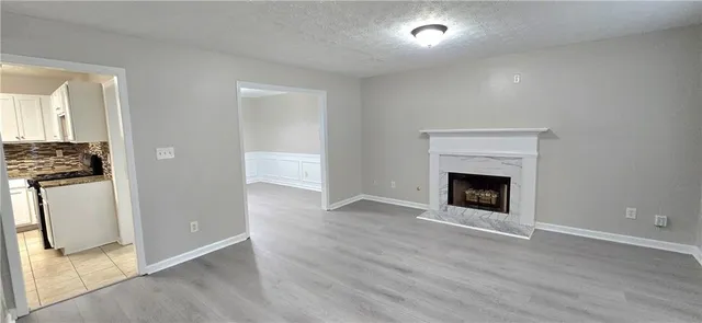 an empty room with wooden floor and a fireplace