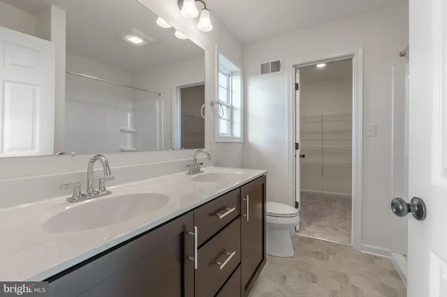 a bathroom with a double vanity sink toilet and shower