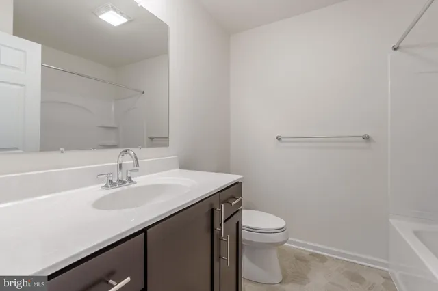 a bathroom with a sink a toilet a vanity and mirror
