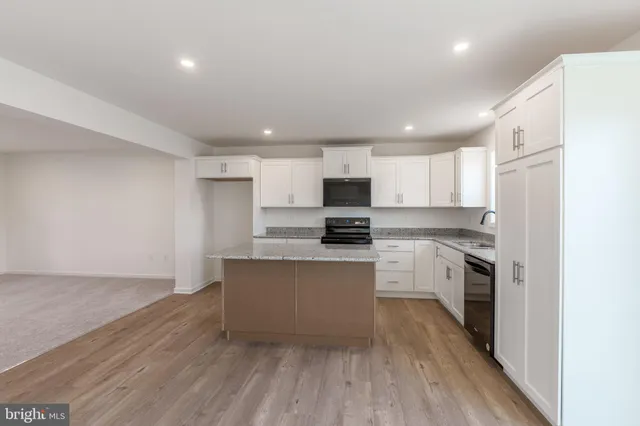 a kitchen with granite countertop white cabinets and stainless steel appliances