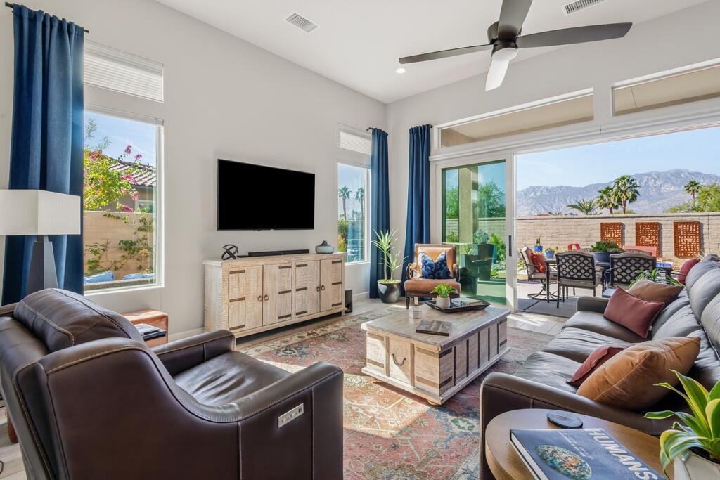 77 Barolo Rancho Mirage, CA 92270 - Photo 19 of 61 a living room with furniture a flat screen tv and a floor to ceiling window