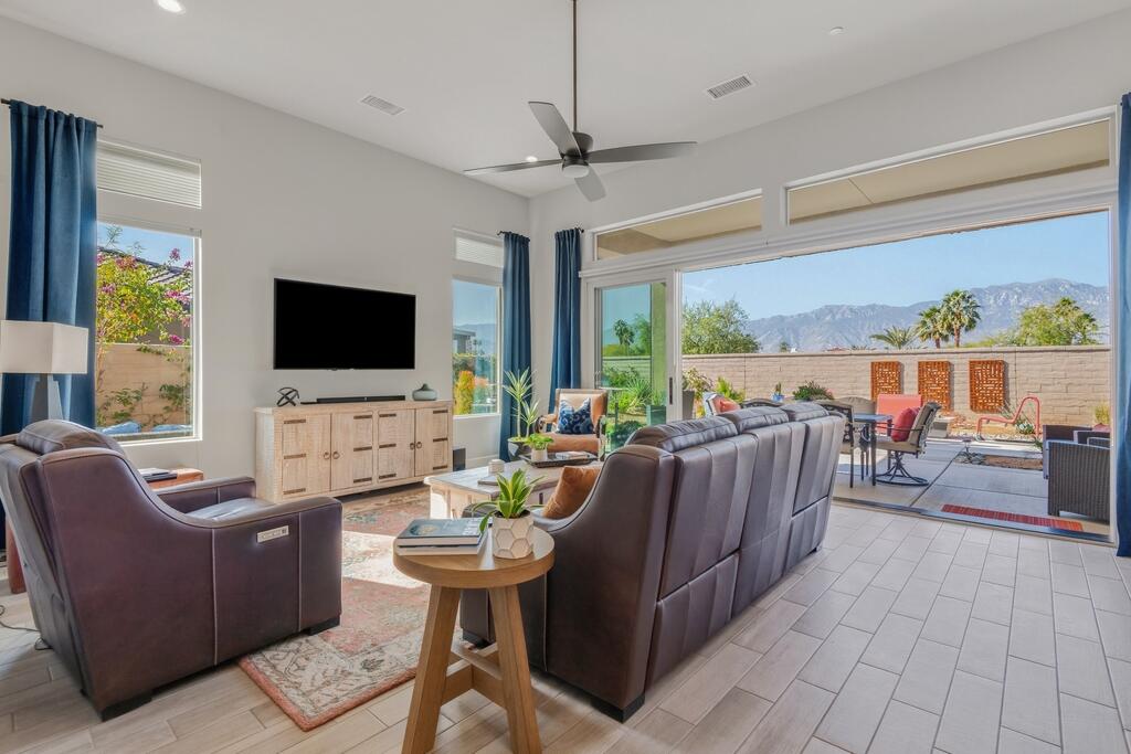 77 Barolo Rancho Mirage, CA 92270 - Photo 20 of 61 a living room with furniture a flat screen tv and a floor to ceiling window