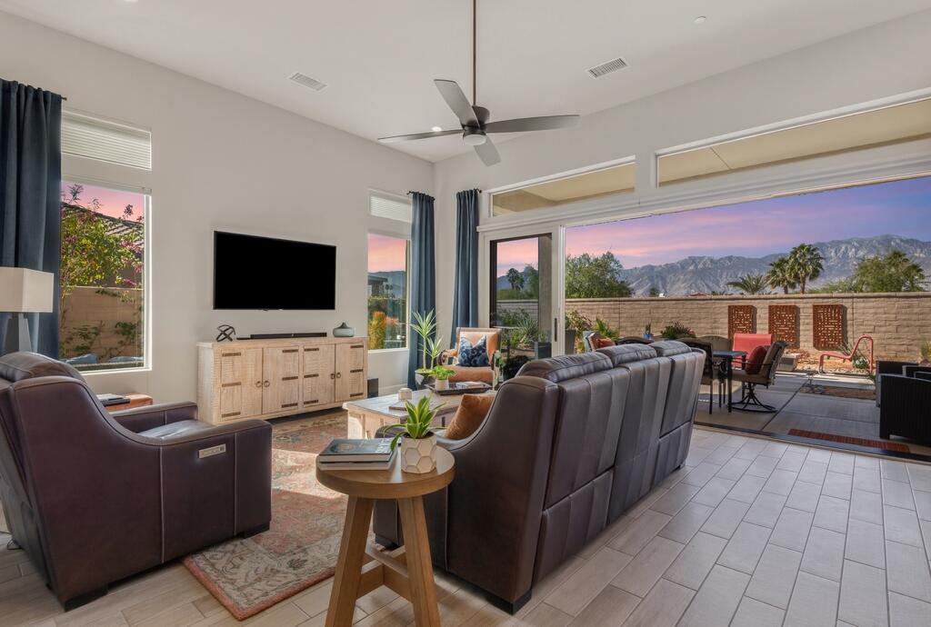 77 Barolo Rancho Mirage, CA 92270 - Photo 21 of 61 a living room with furniture a flat screen tv and a floor to ceiling window