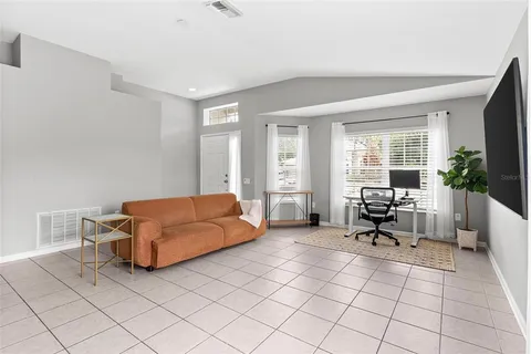 a living room with furniture a flat screen tv and a large window