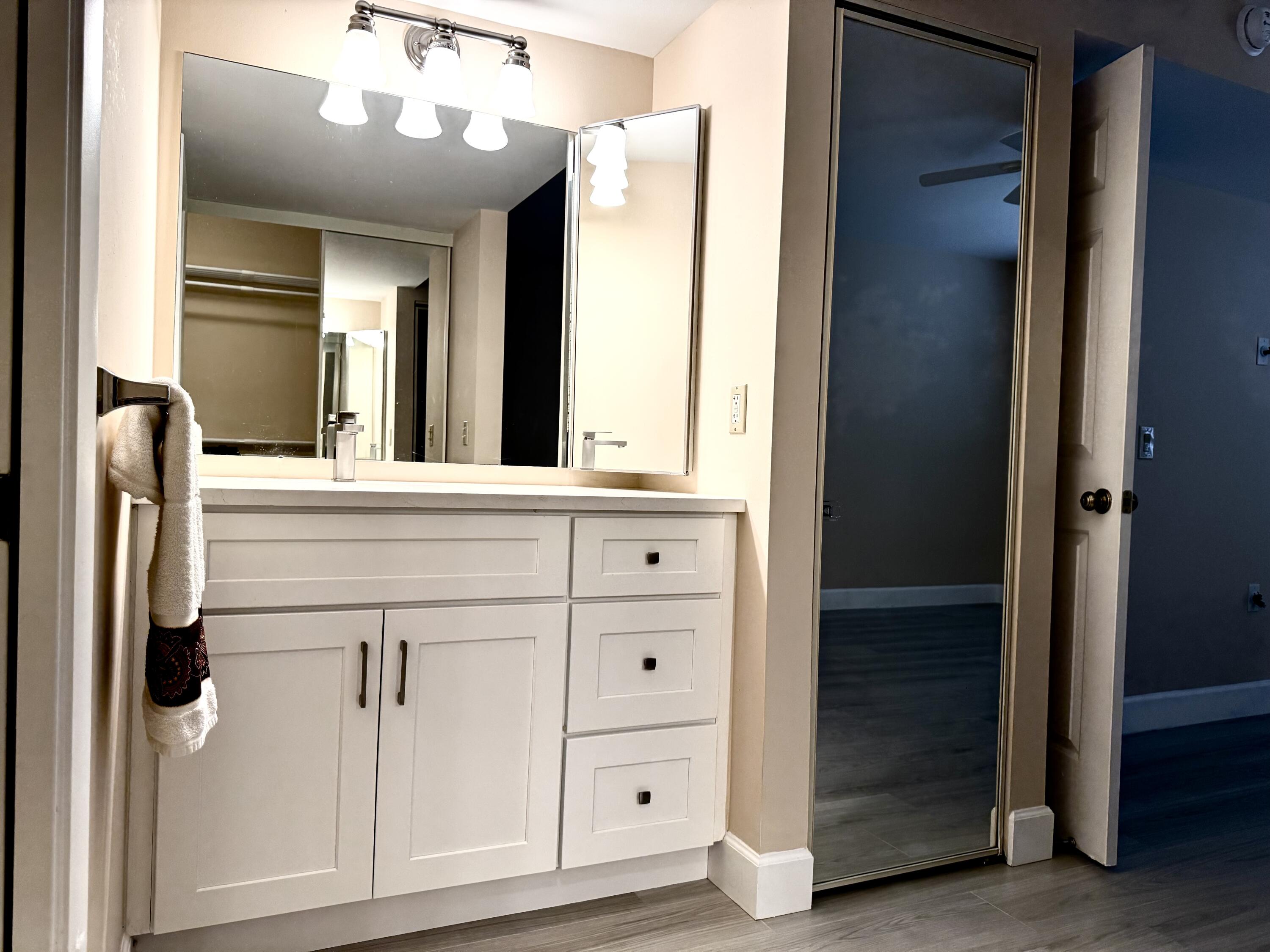 6025 Balboa Circle, Unit 406 Boca Raton, FL 33433 - Photo 12 of 33 a bathroom with a sink a large mirror and a shower