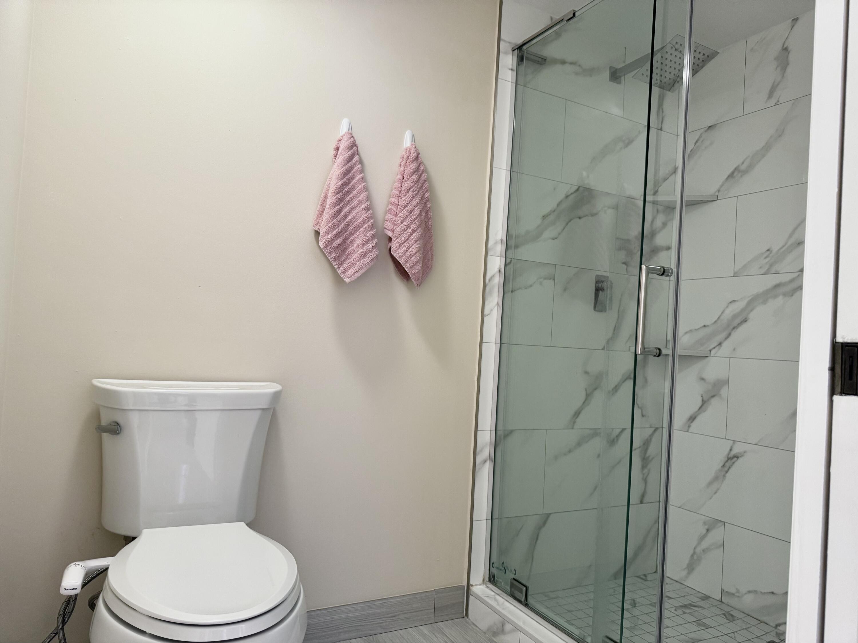 6025 Balboa Circle, Unit 406 Boca Raton, FL 33433 - Photo 14 of 33 a white toilet sitting next to a shower