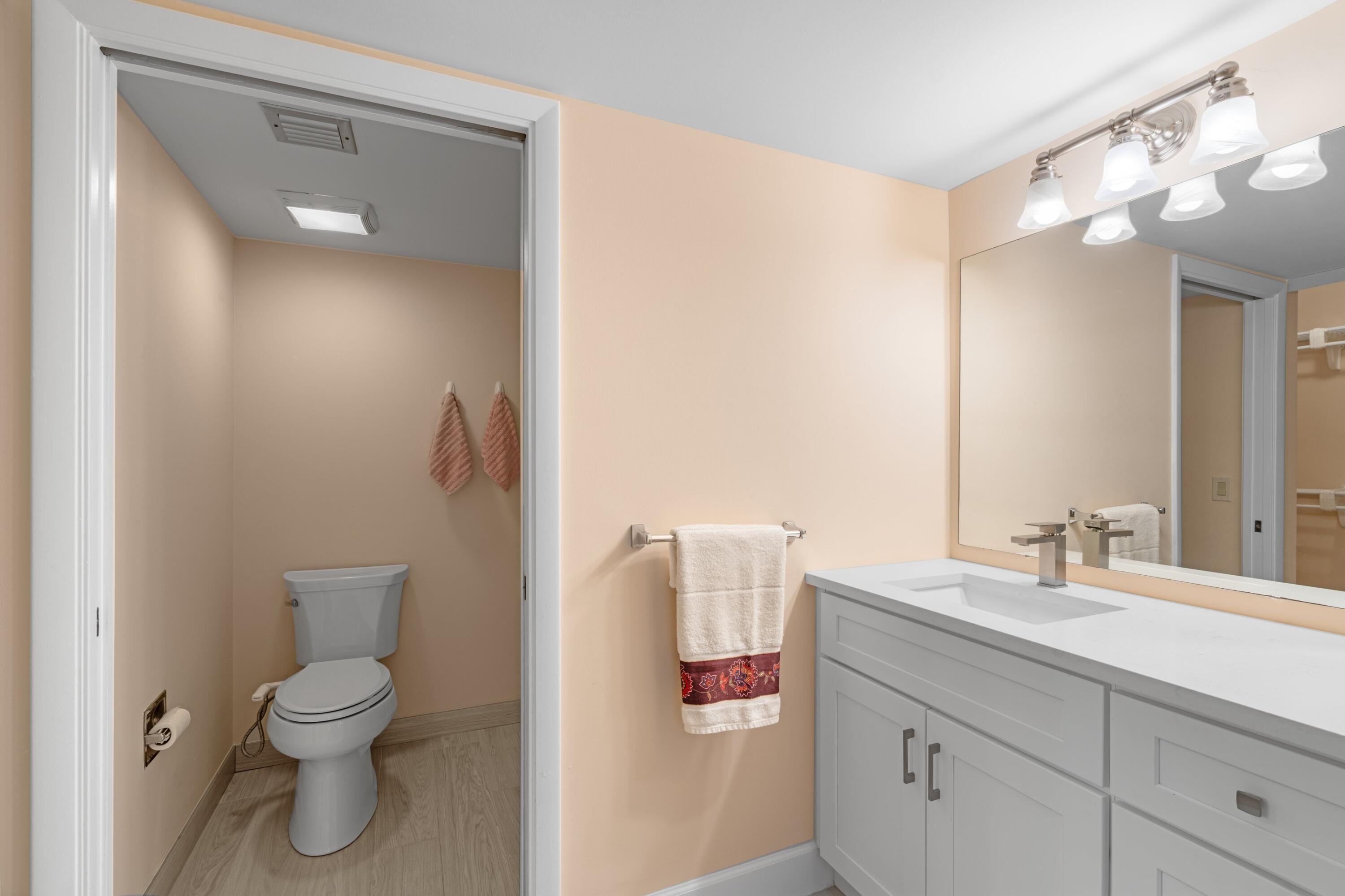 6025 Balboa Circle, Unit 406 Boca Raton, FL 33433 - Photo 15 of 33 a bathroom with a toilet sink and mirror