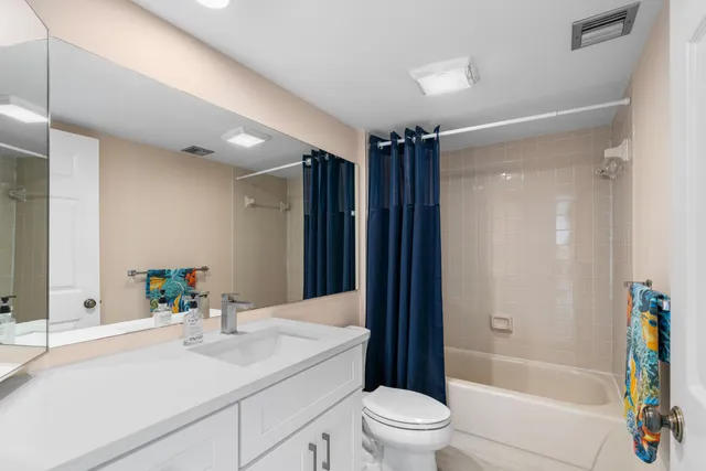 a bathroom with a sink a toilet a tub and shower