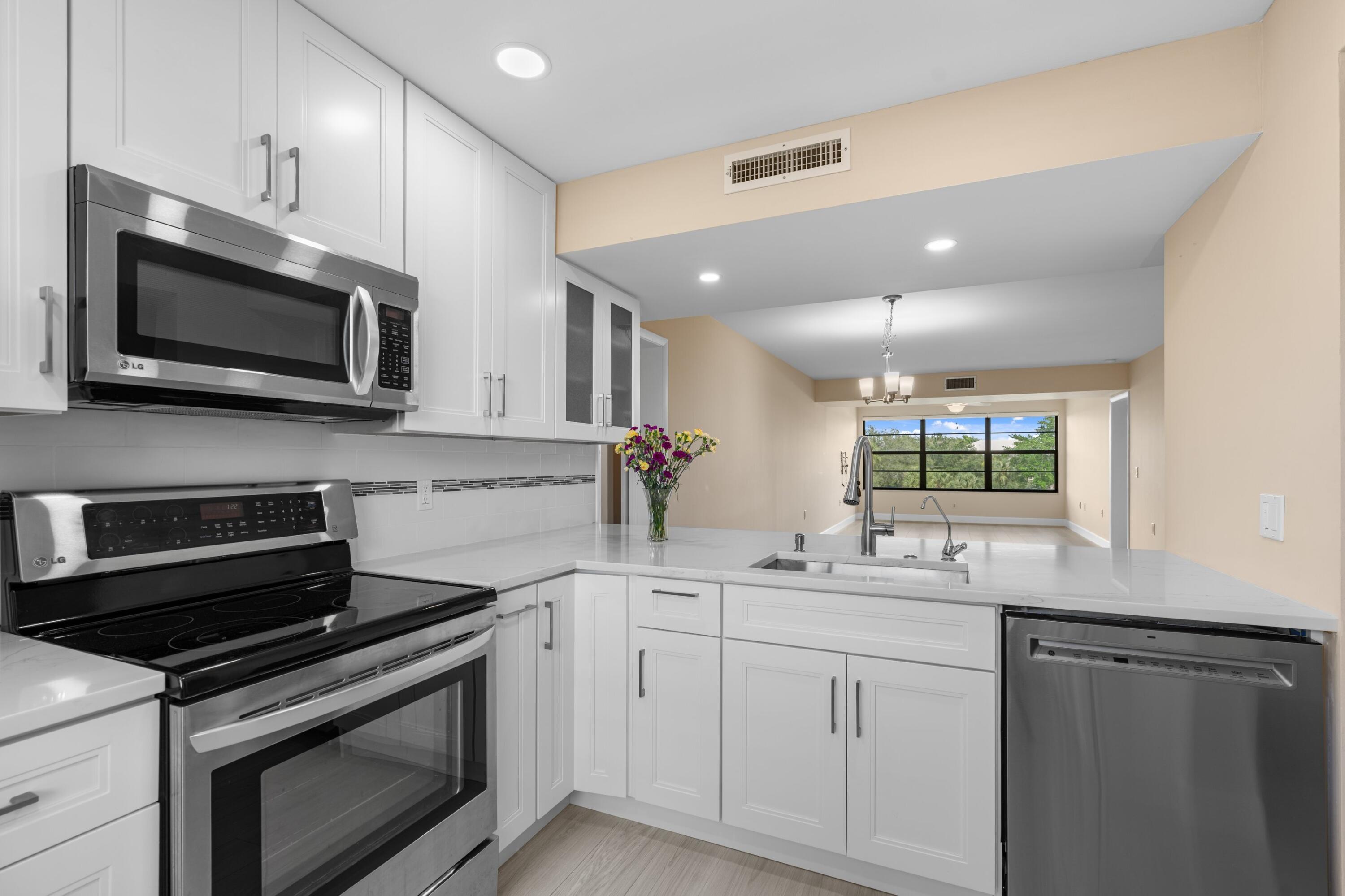 6025 Balboa Circle, Unit 406 Boca Raton, FL 33433 - Photo 2 of 33 a kitchen with a sink stove and microwave
