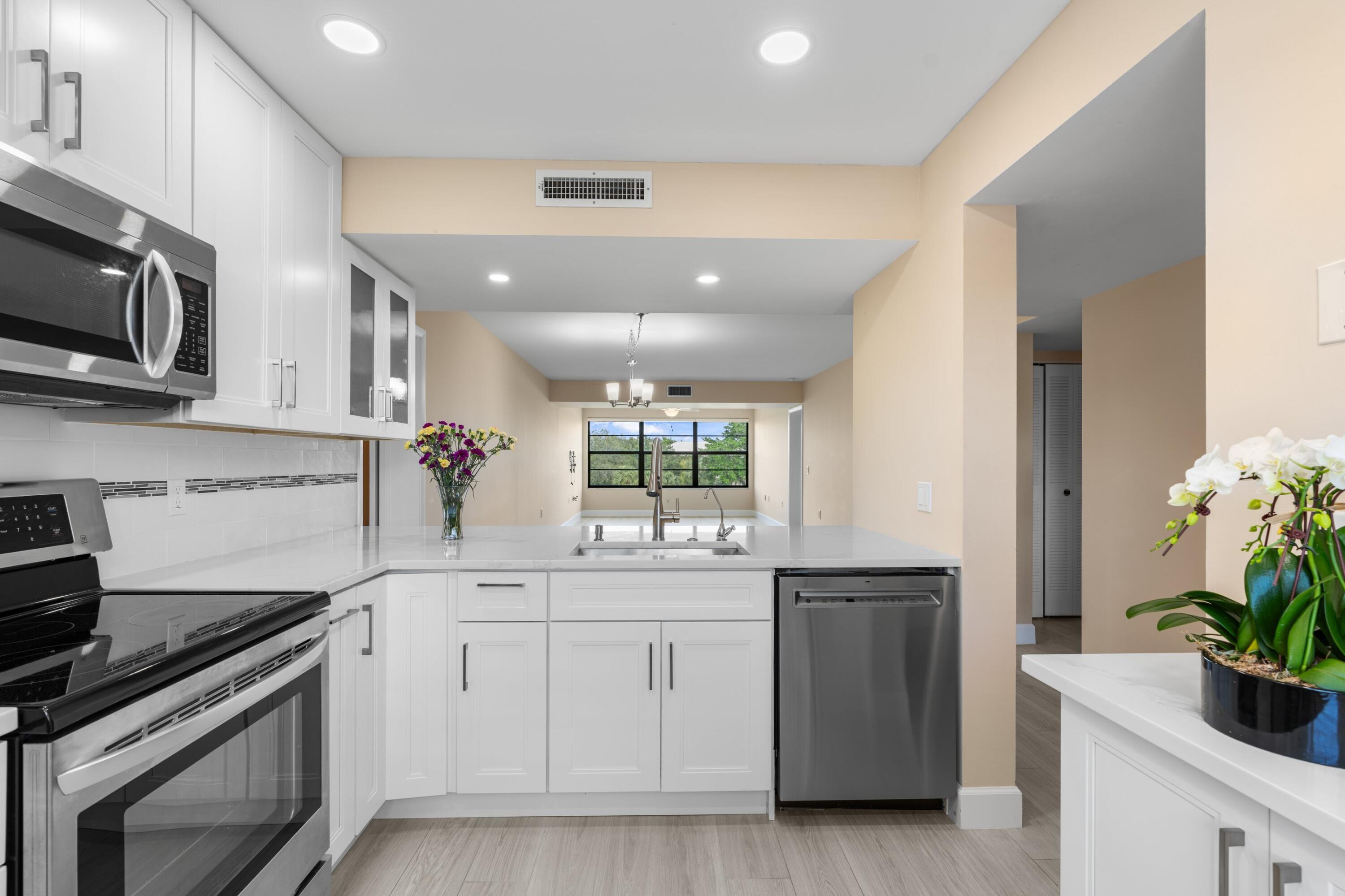 6025 Balboa Circle, Unit 406 Boca Raton, FL 33433 - Photo 3 of 33 a kitchen with a sink stove and microwave
