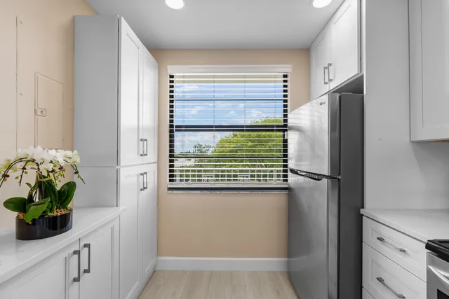 a view of a kitchen with a sink and a refrigerator