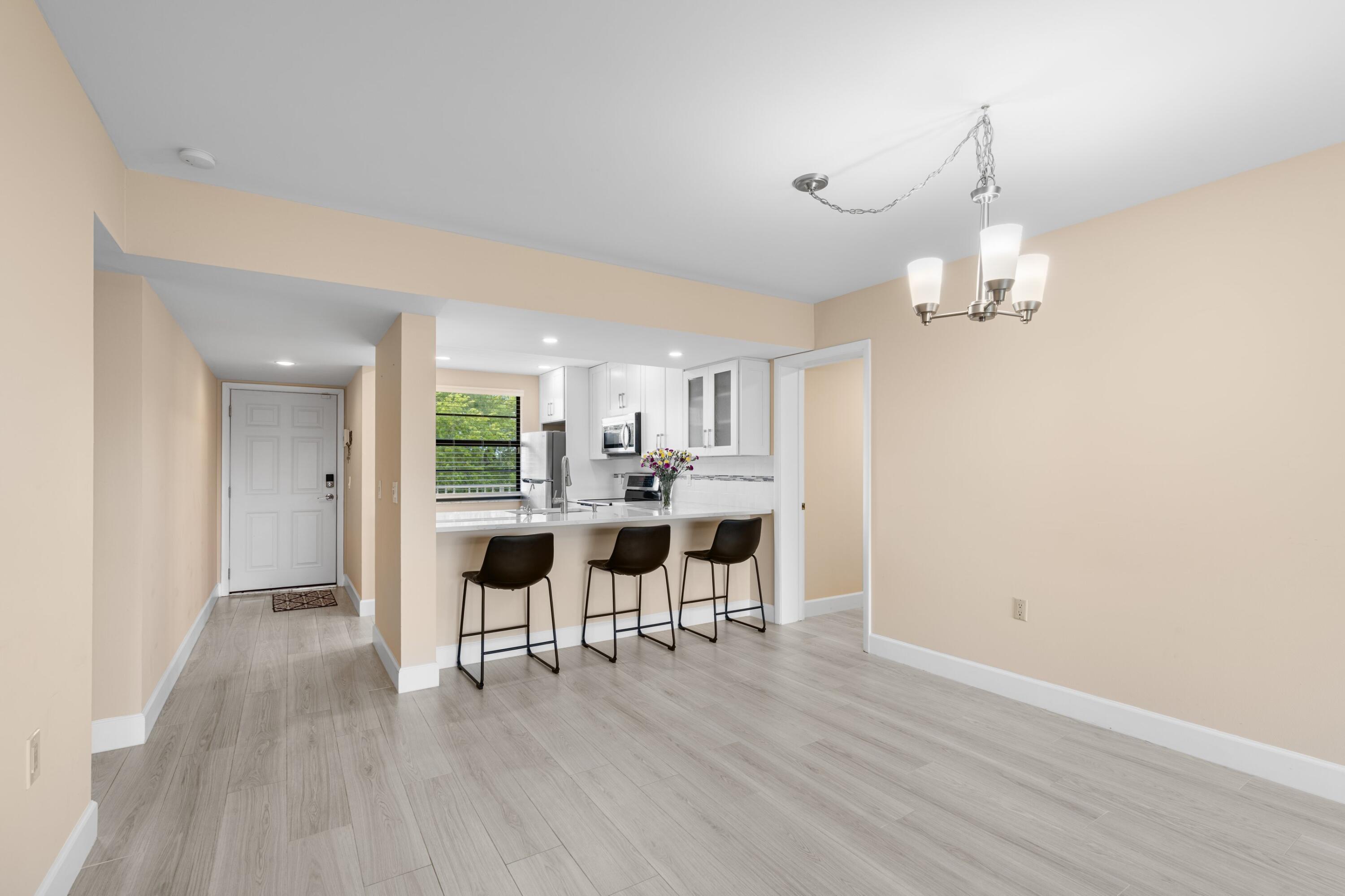 6025 Balboa Circle, Unit 406 Boca Raton, FL 33433 - Photo 5 of 33 a view of a dining room with furniture and wooden floor