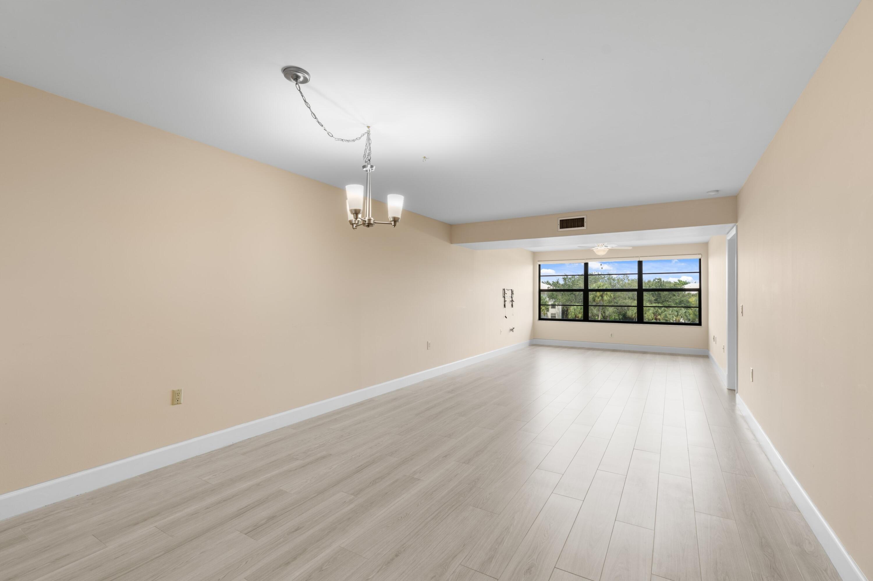 6025 Balboa Circle, Unit 406 Boca Raton, FL 33433 - Photo 7 of 33 wooden floor in an empty room with a window