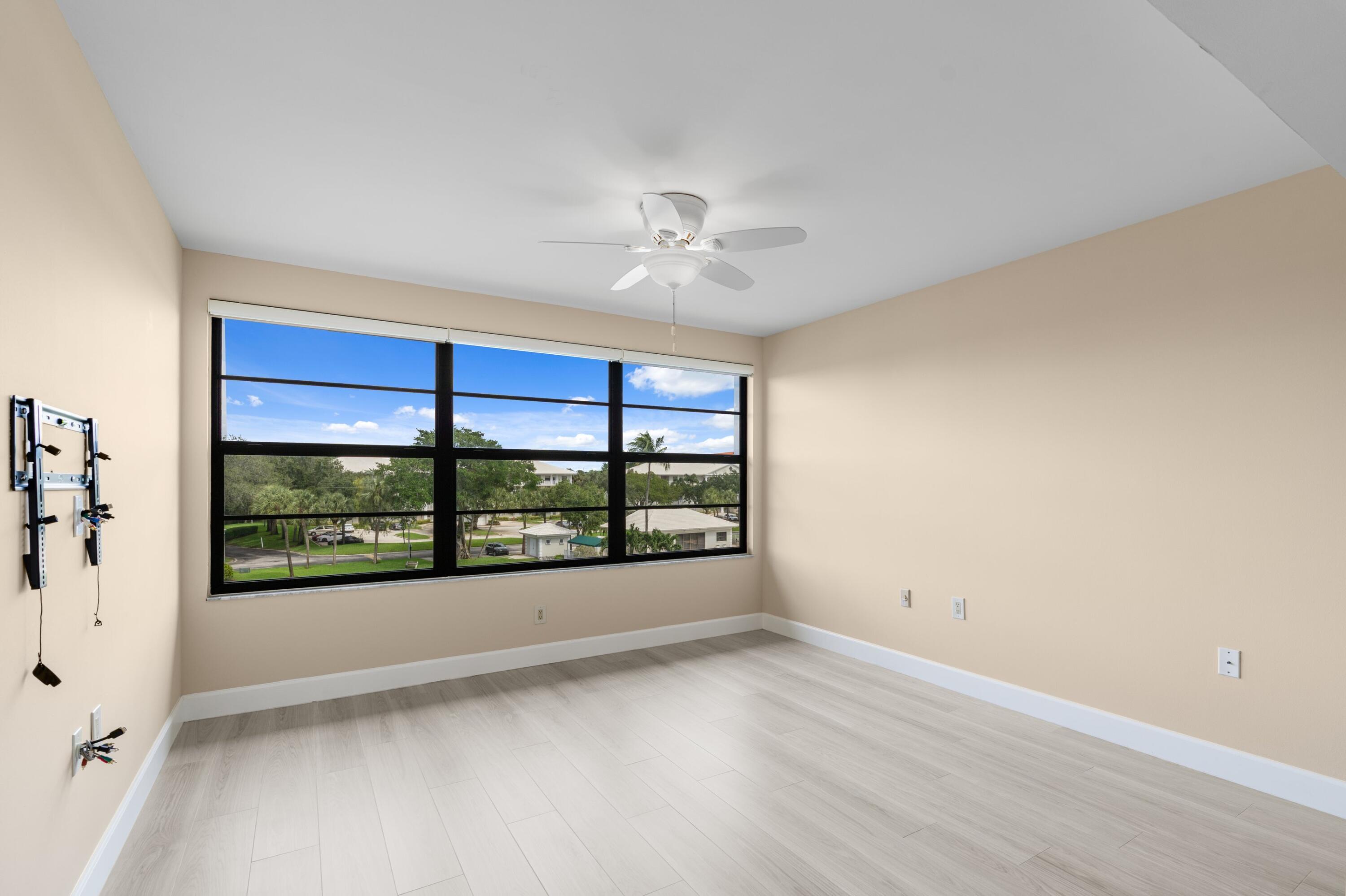 6025 Balboa Circle, Unit 406 Boca Raton, FL 33433 - Photo 8 of 33 an empty room with windows and ceiling fan