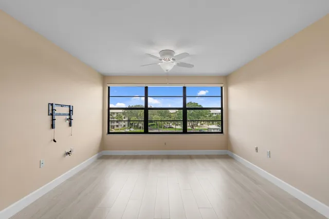 an empty room with windows and hardwood floor