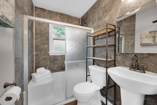 a bathroom with a sink toilet and shower