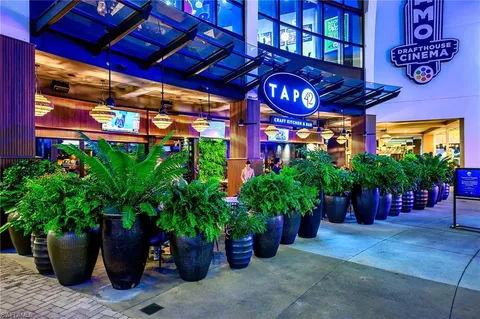 a view of a multi story building with a yard and potted plants