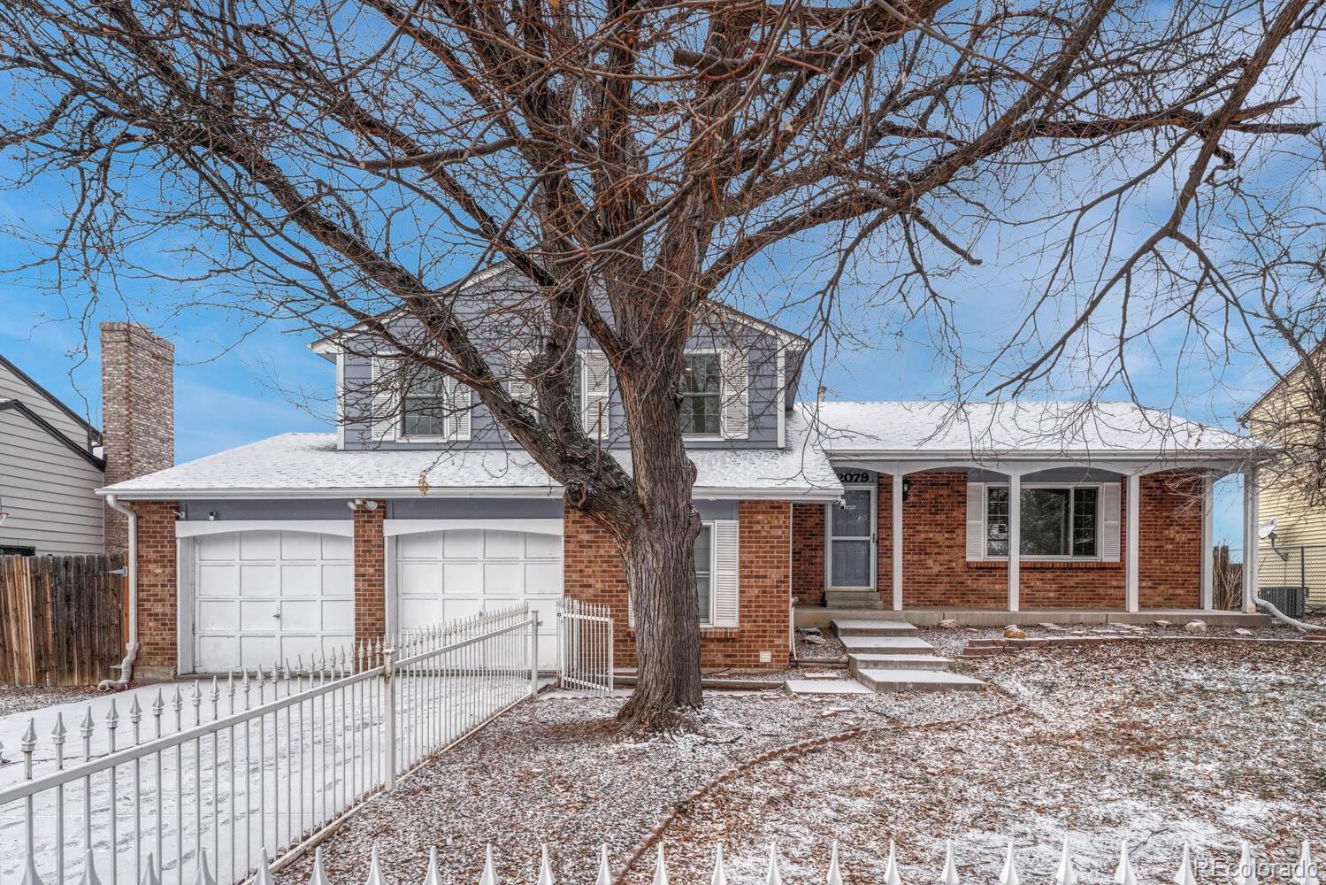a front view of a house with a tree