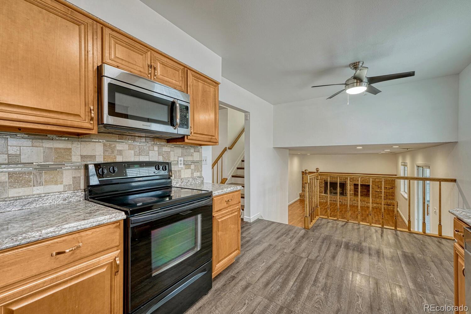 2079 South Quintero Street Aurora, CO 80013 - Photo 13 of 37 a kitchen with wooden floors and stainless steel appliances