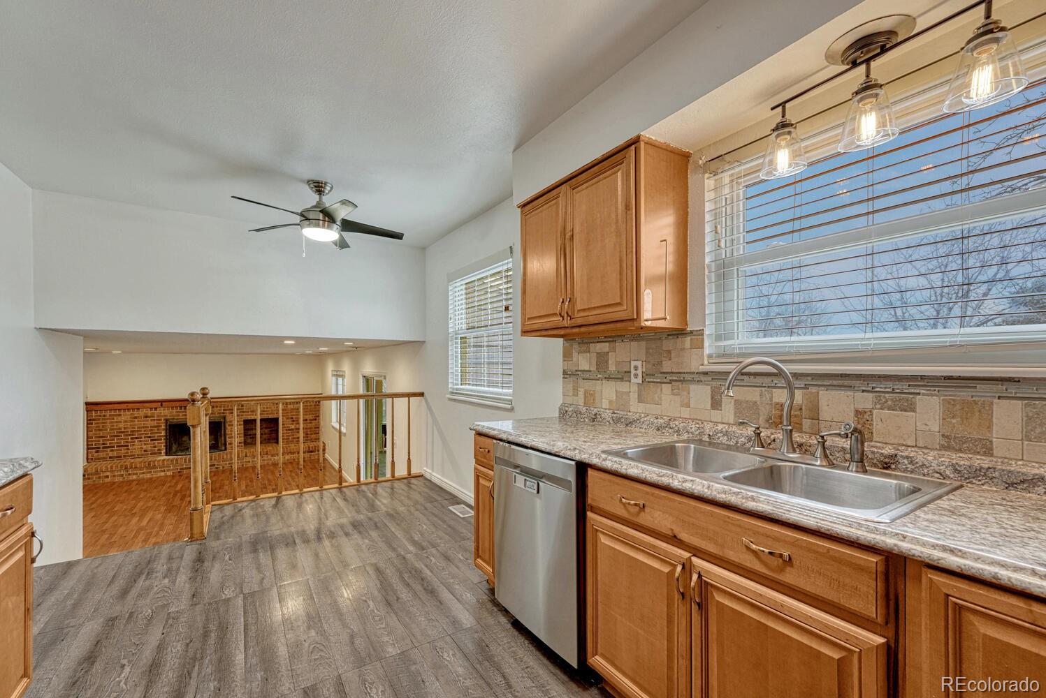 2079 South Quintero Street Aurora, CO 80013 - Photo 14 of 37 a kitchen with stainless steel appliances granite countertop a sink and wooden cabinets