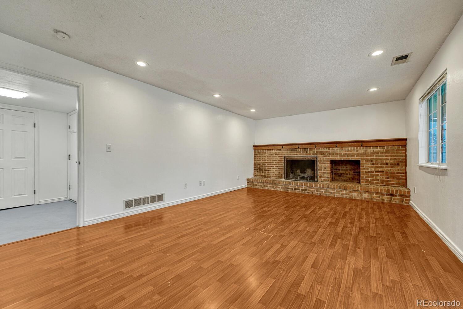 2079 South Quintero Street Aurora, CO 80013 - Photo 16 of 37 a view of empty room with wooden floor and fireplace
