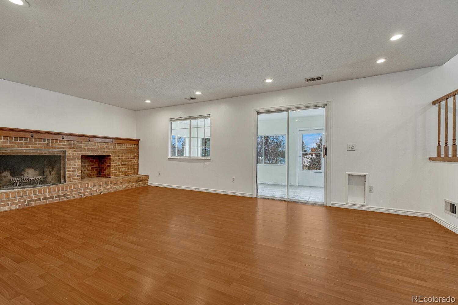 2079 South Quintero Street Aurora, CO 80013 - Photo 16 of 35 a view of a livingroom with wooden floor and a fireplace