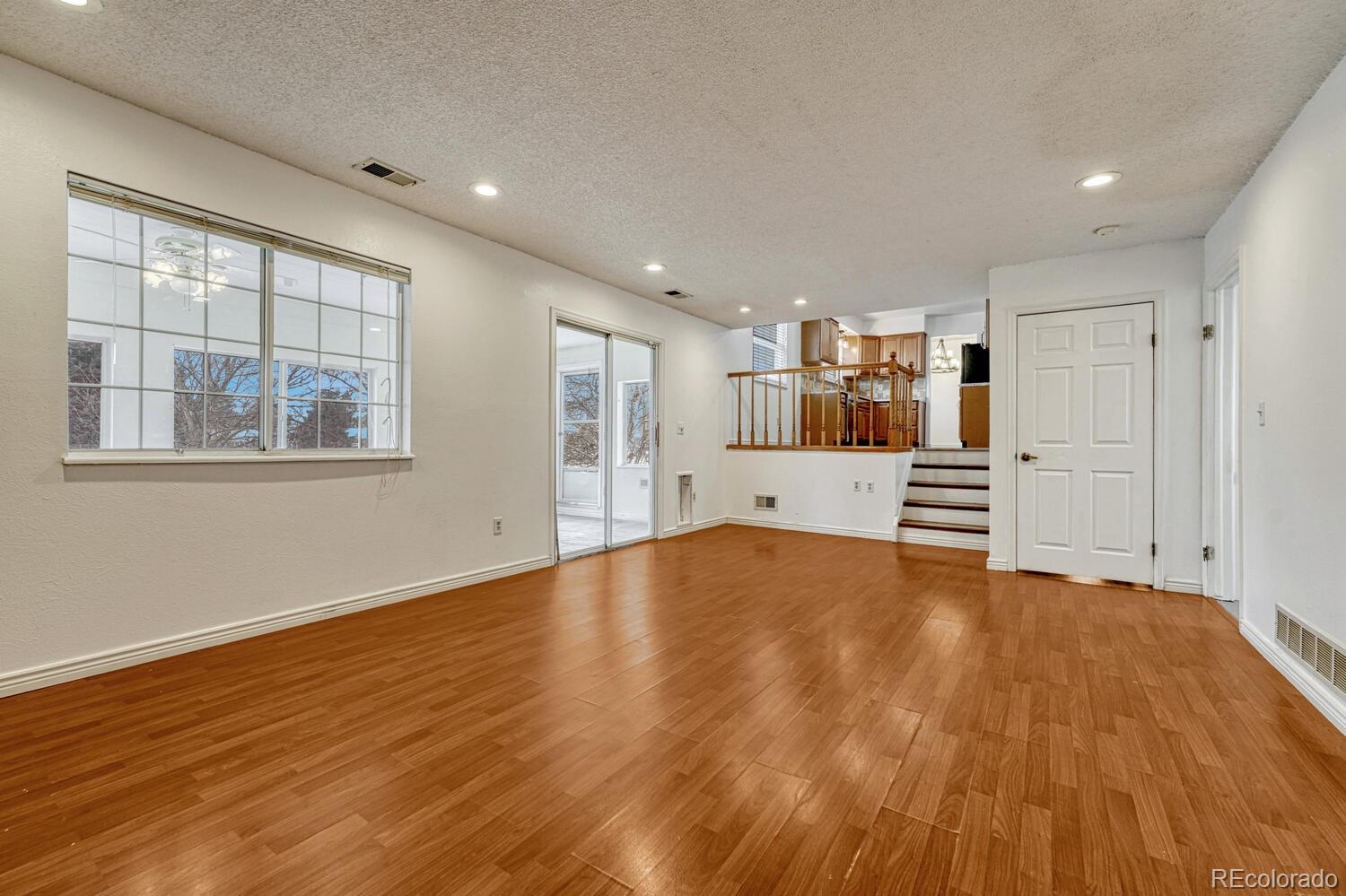 2079 South Quintero Street Aurora, CO 80013 - Photo 17 of 37 a view of an empty room with a window and wooden floor