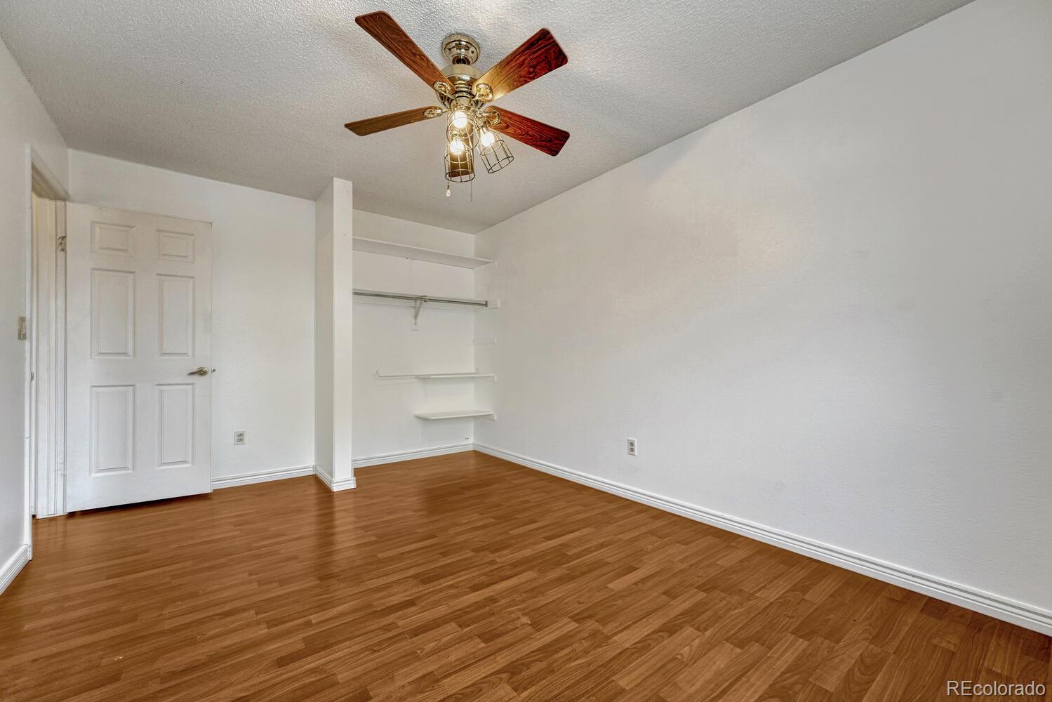 2079 South Quintero Street Aurora, CO 80013 - Photo 25 of 35 an empty room with wooden floor and windows