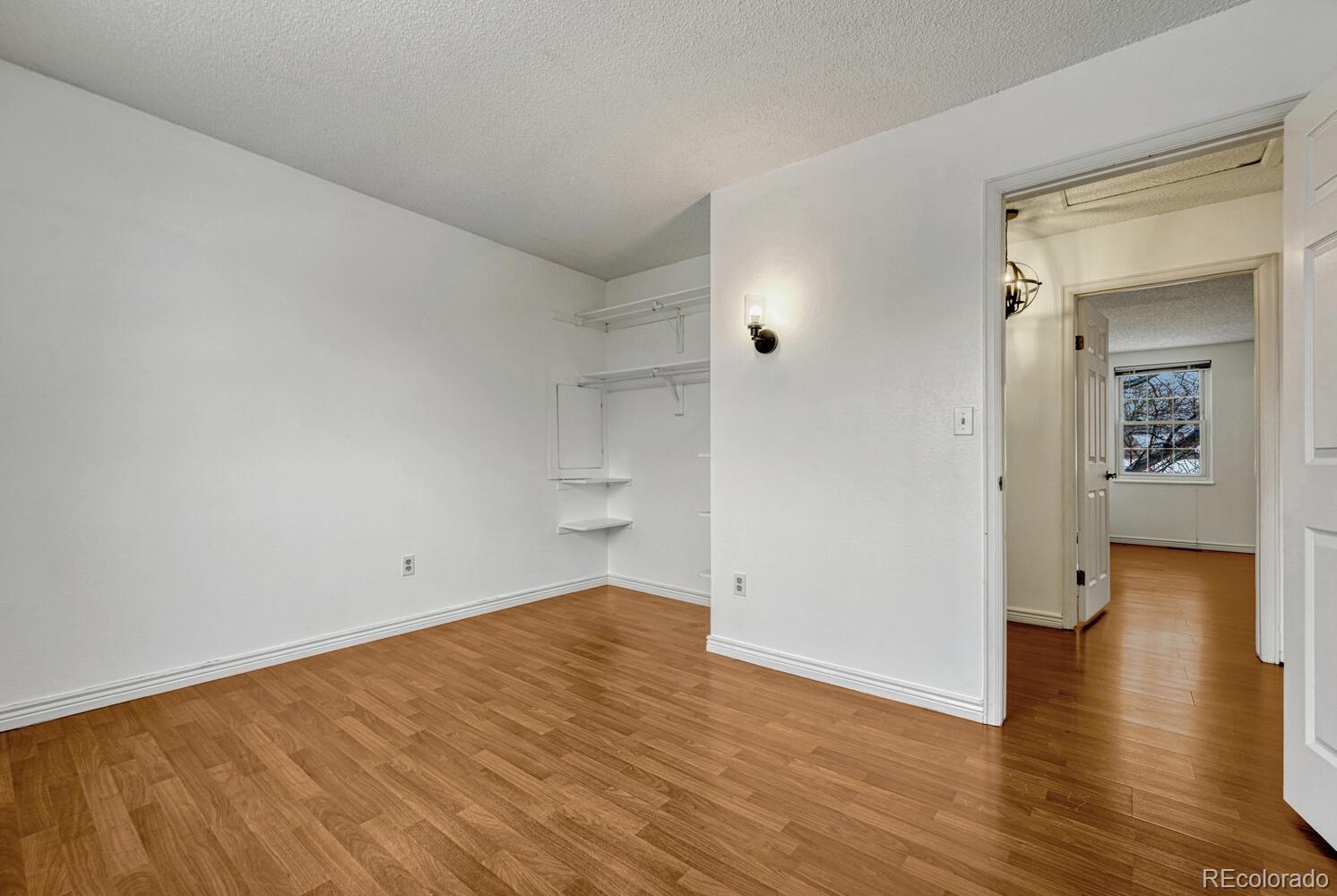 2079 South Quintero Street Aurora, CO 80013 - Photo 27 of 35 an empty room with wooden floor and a bathroom