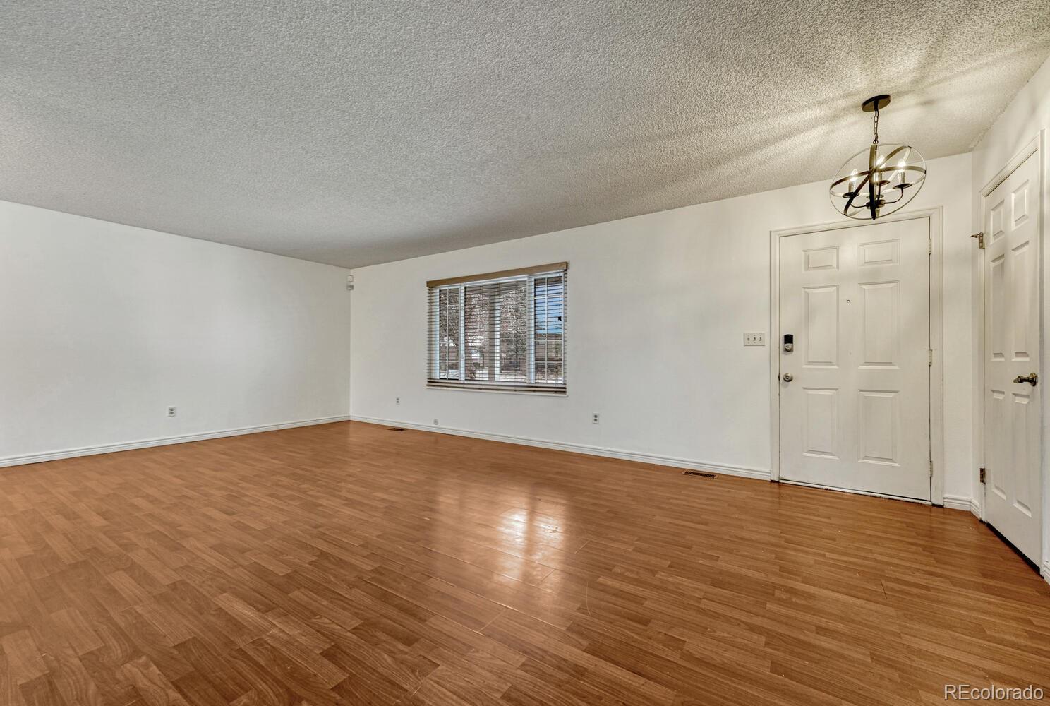 2079 South Quintero Street Aurora, CO 80013 - Photo 5 of 35 a view of an empty room with wooden floor and a window